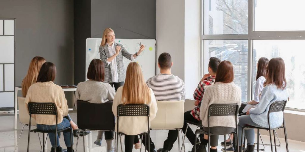 A group of young adults attending an interactive workshop session, representing students participating in a UK degree apprenticeship training seminar.