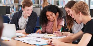 Students collaborating on UCAS personal statement research in a library