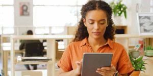 A focused young female student using a tablet to research available university courses and navigate the UCAS Clearing 2026 process.