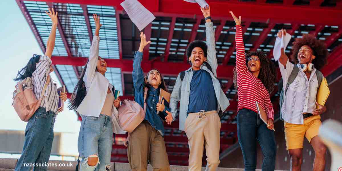 A group of diverse students cheering and throwing result papers in the air to celebrate A-Level Results Day 2026 in the UK.
