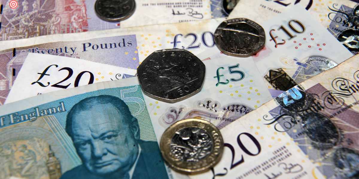 A close-up of British pound banknotes and coins, representing UK student finance funding and university loan eligibility.