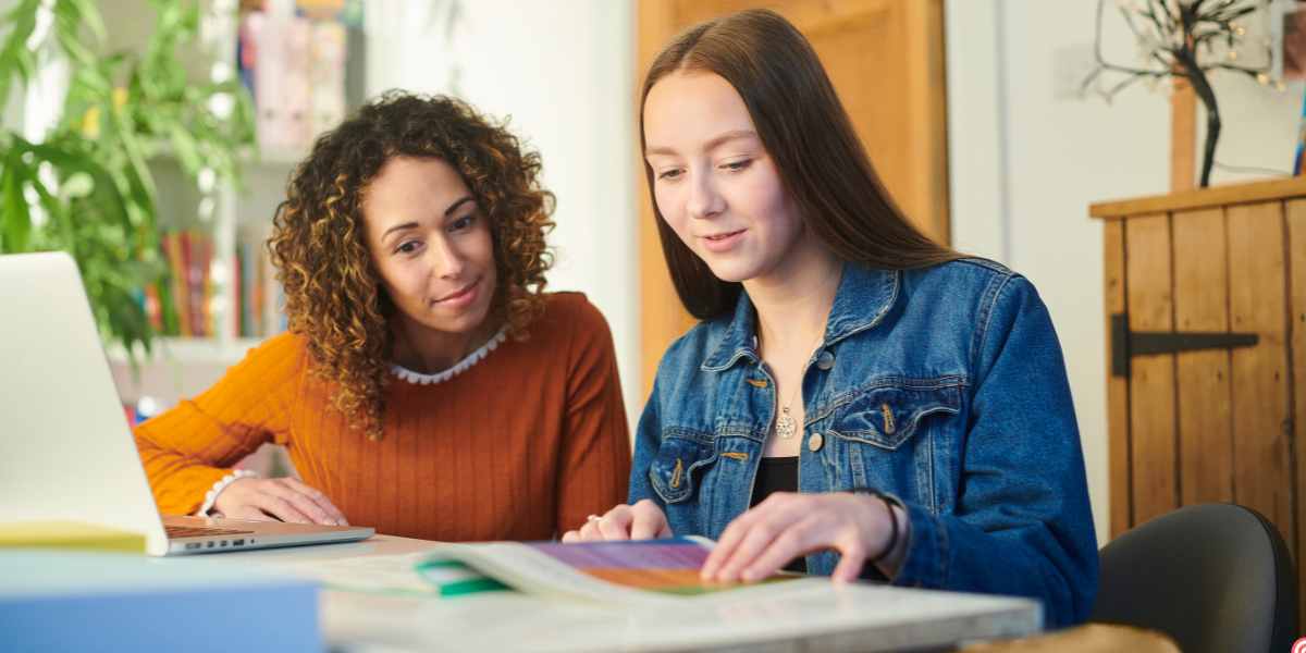 A student and her mother or advisor sitting at a table together, reviewing documents to meet the Student Finance deadline.